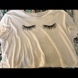 White shirt with eyelashes and writing